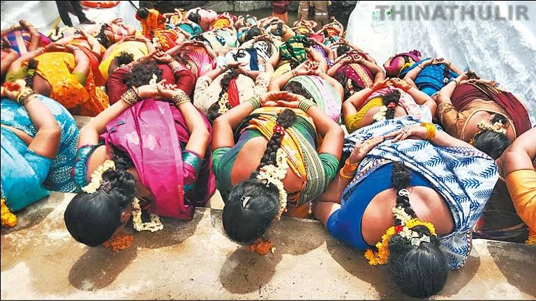 மண்டியிட்டு கைகளை பின்புறமாக கட்டிக்கொண்டு மண் சோறு சாப்பிட்ட பெண்கள்